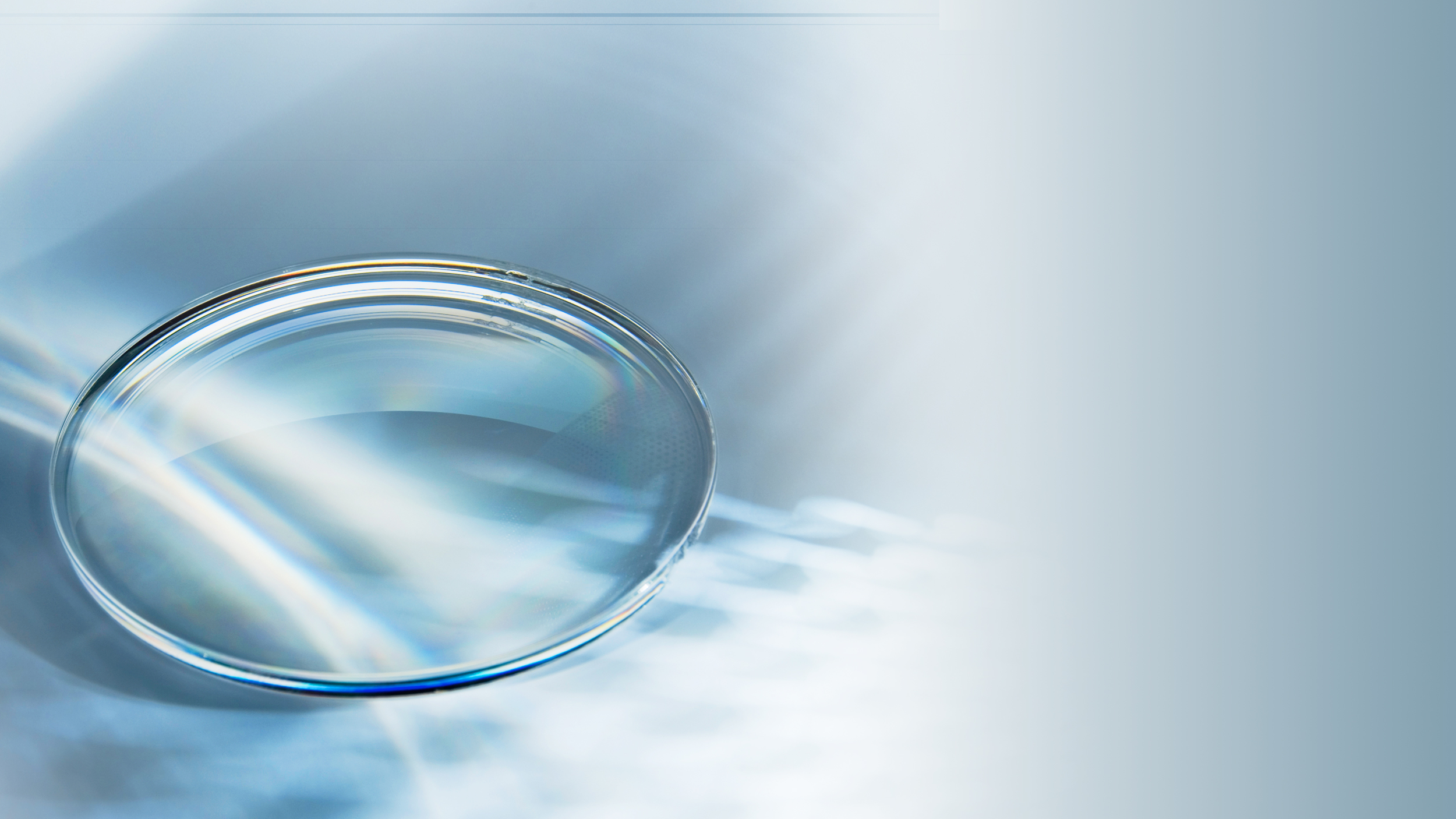 Optometrist fitting a contact lens for a client