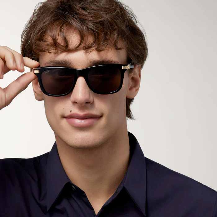Man wearing Cartier glasses for men, gold Santos frame with screw motif